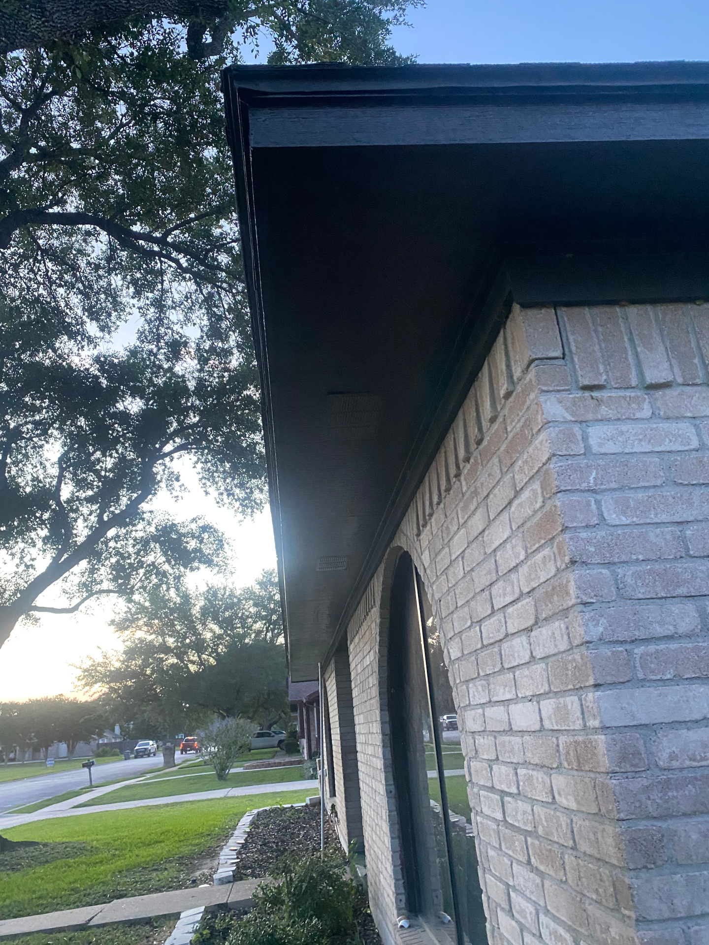 Freshly painted black fascia and soffit on a brick Victoria TX home