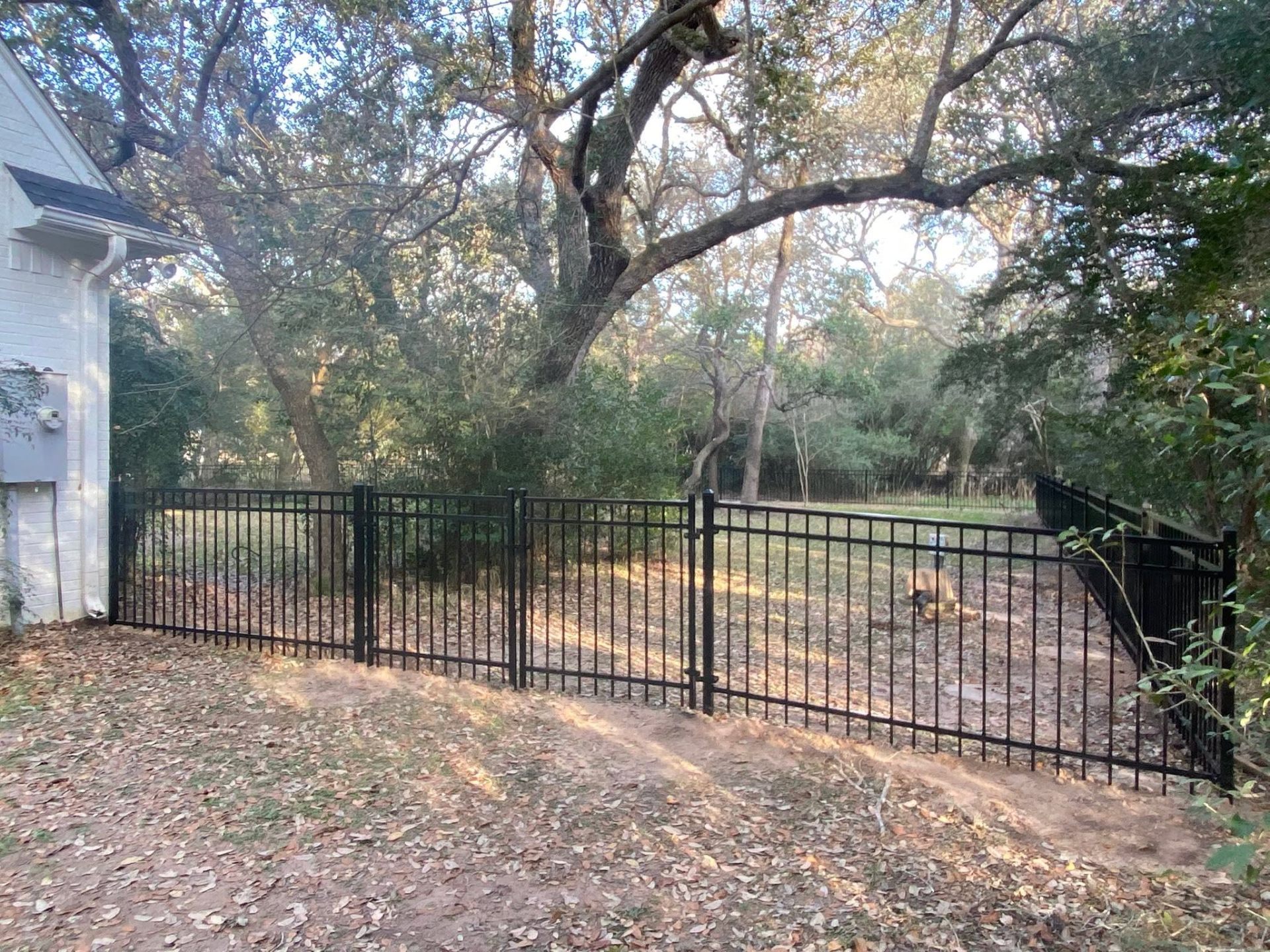 Black aluminum ornamental fence installed along a Texas backyard