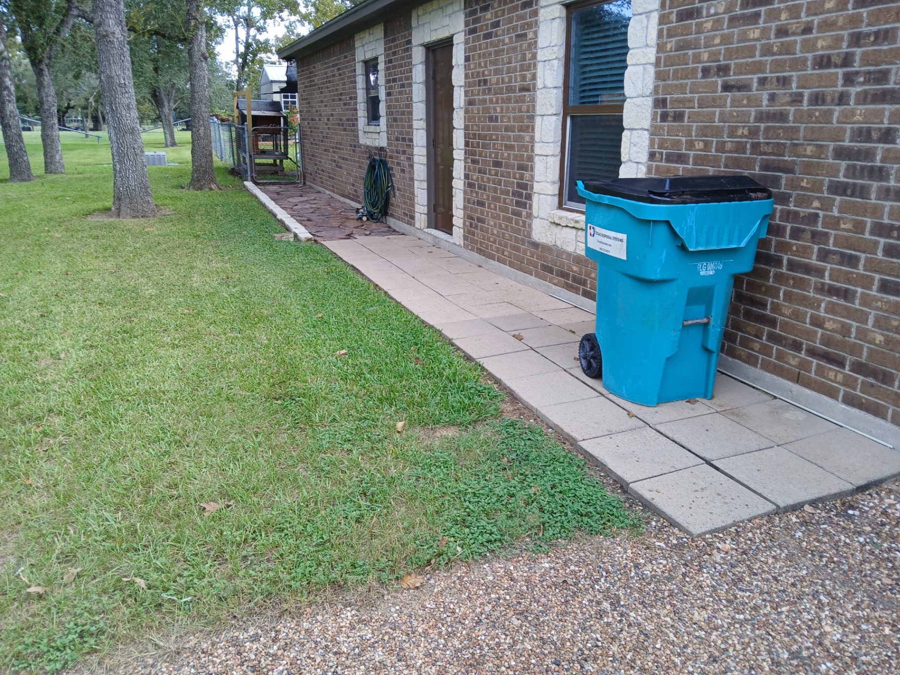 Paver stone walkway running along a brick home in the Victoria, TX area