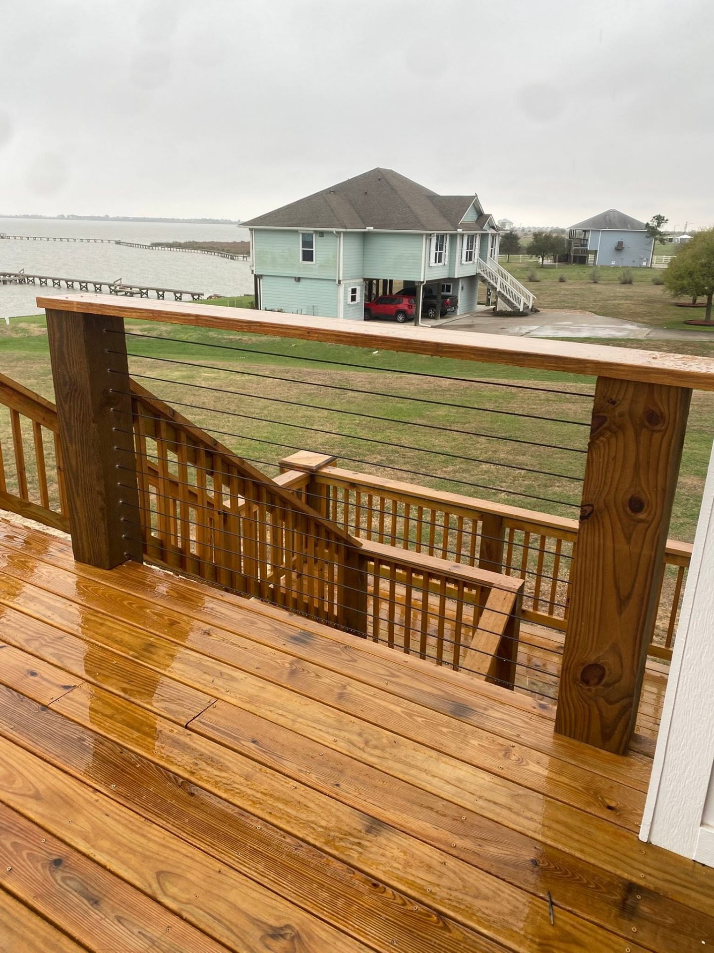 Elevated wood deck with cable railing and bay view