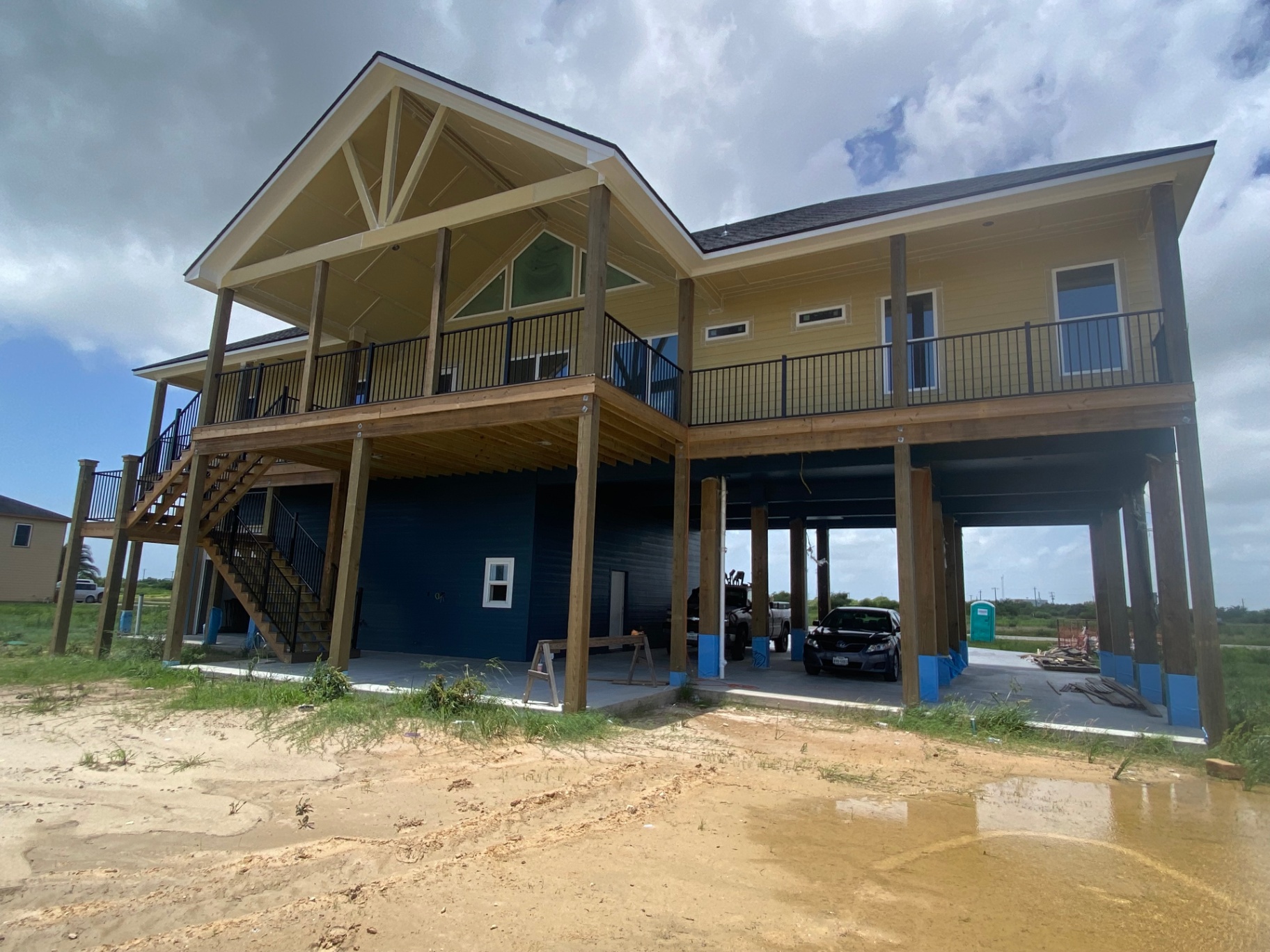 Large elevated waterfront deck and stair system on a raised coastal home