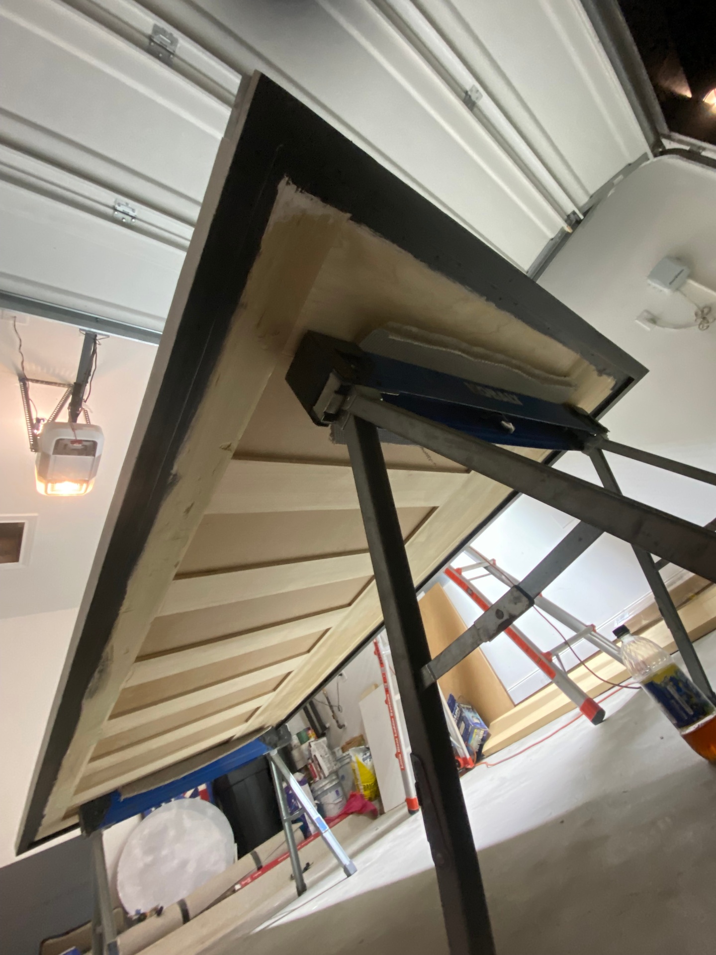 Garage door panel being repaired and refinished in shop