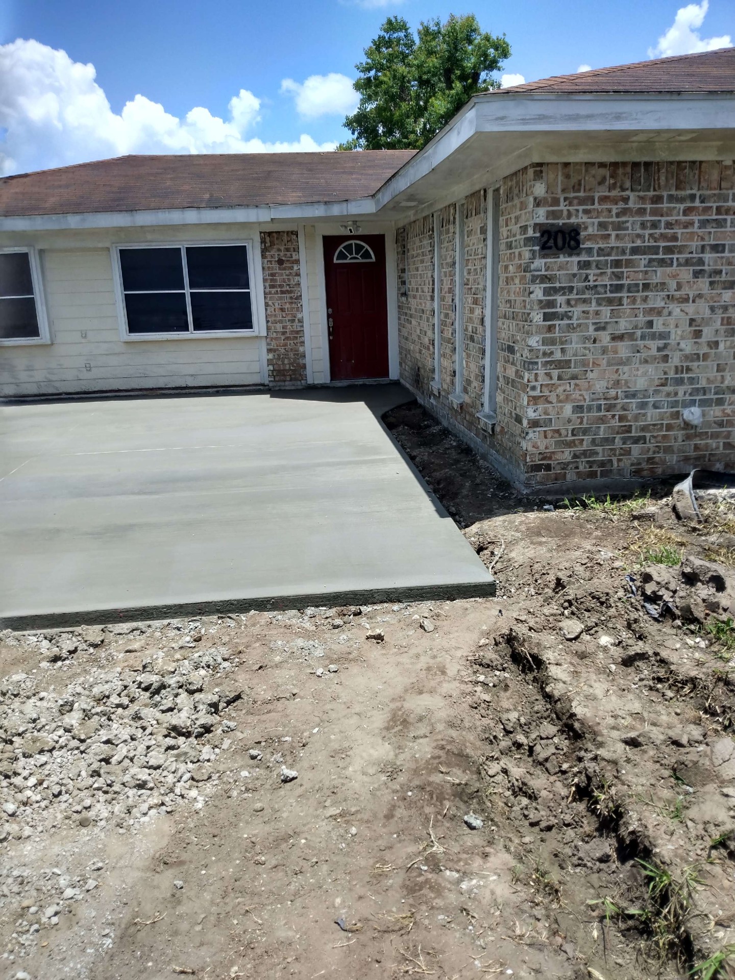 Fresh concrete entry pad and walkway at front door of a Texas home