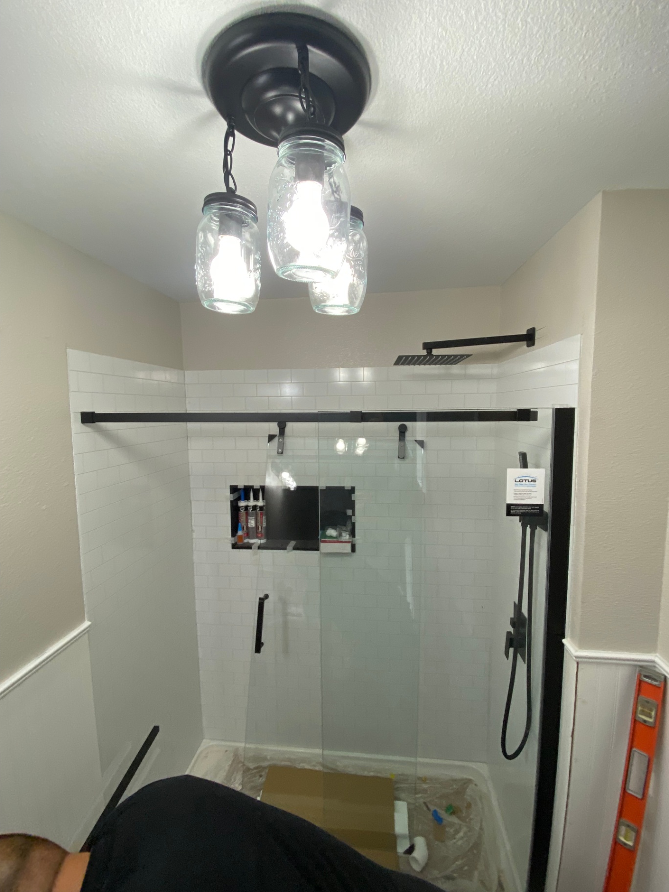 Finished walk-in shower remodel with black fixtures, glass enclosure, and subway tile