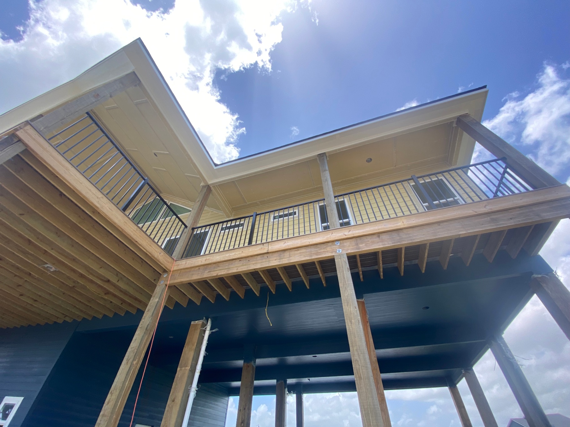 Low-angle view of a raised deck structure with finished railing and framing