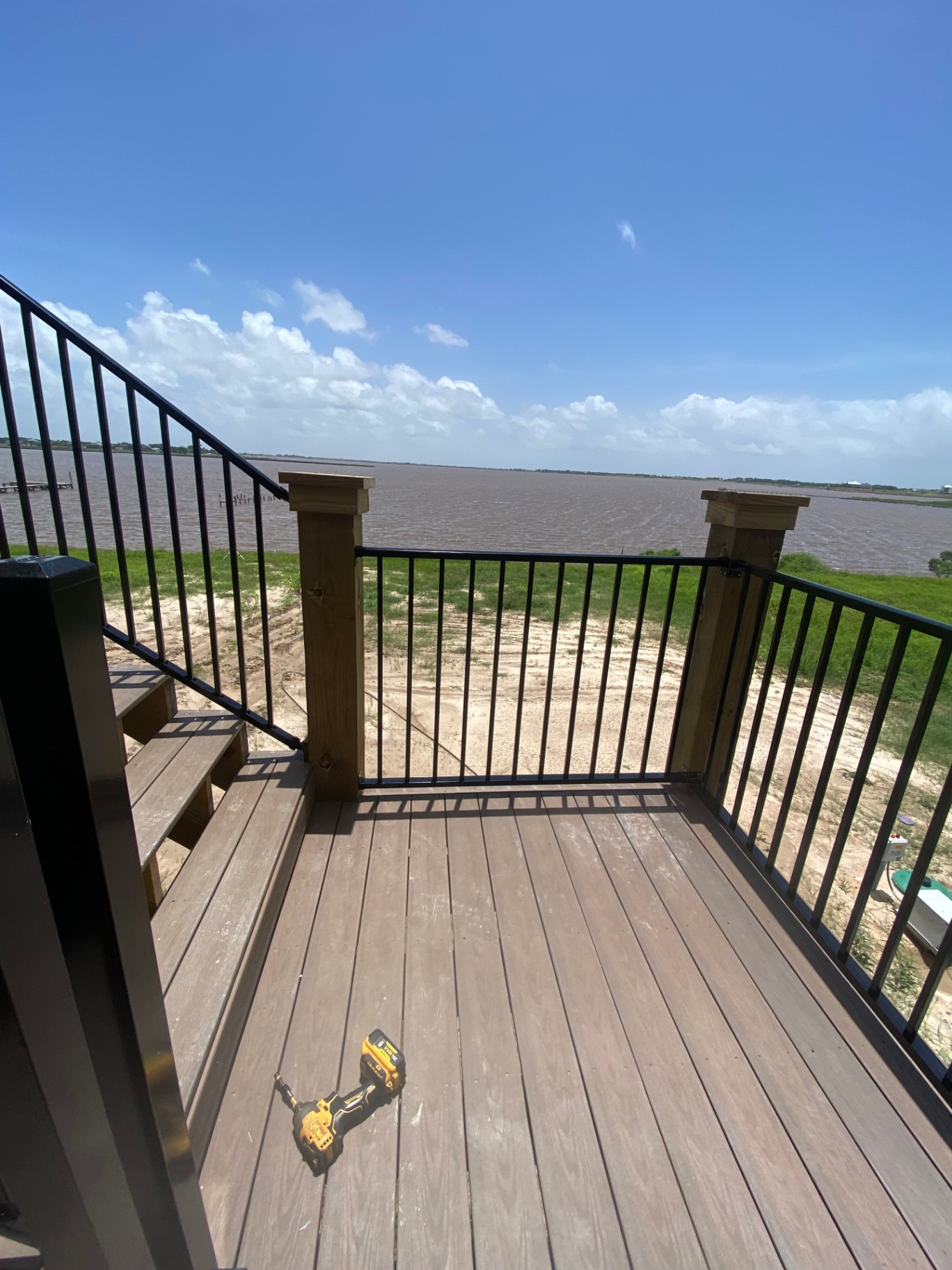 Finished stair landing and deck boards with waterfront view from an elevated home