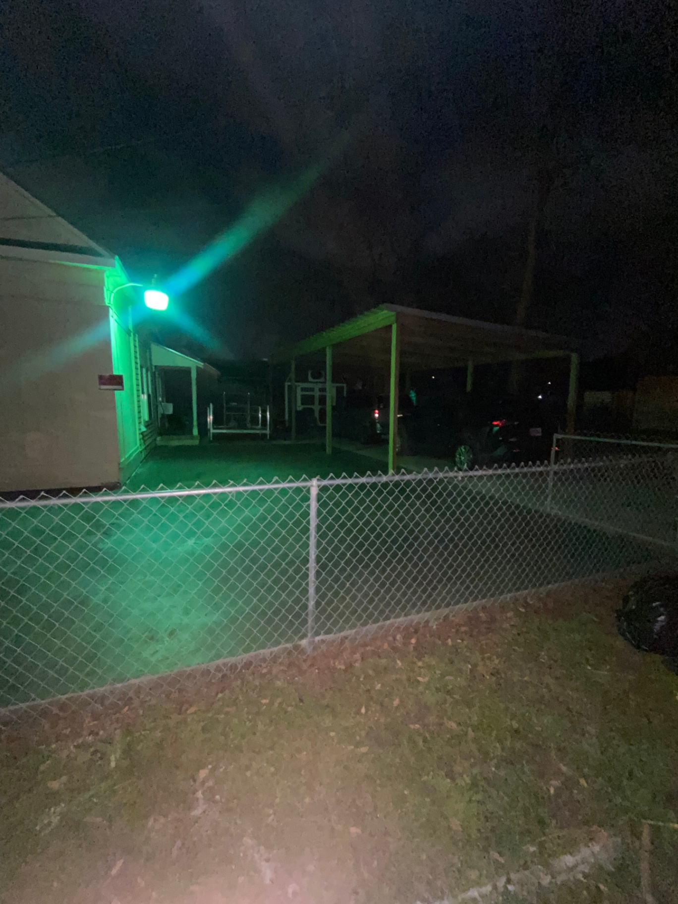 Chain link fence installed around a residential yard, photographed at night