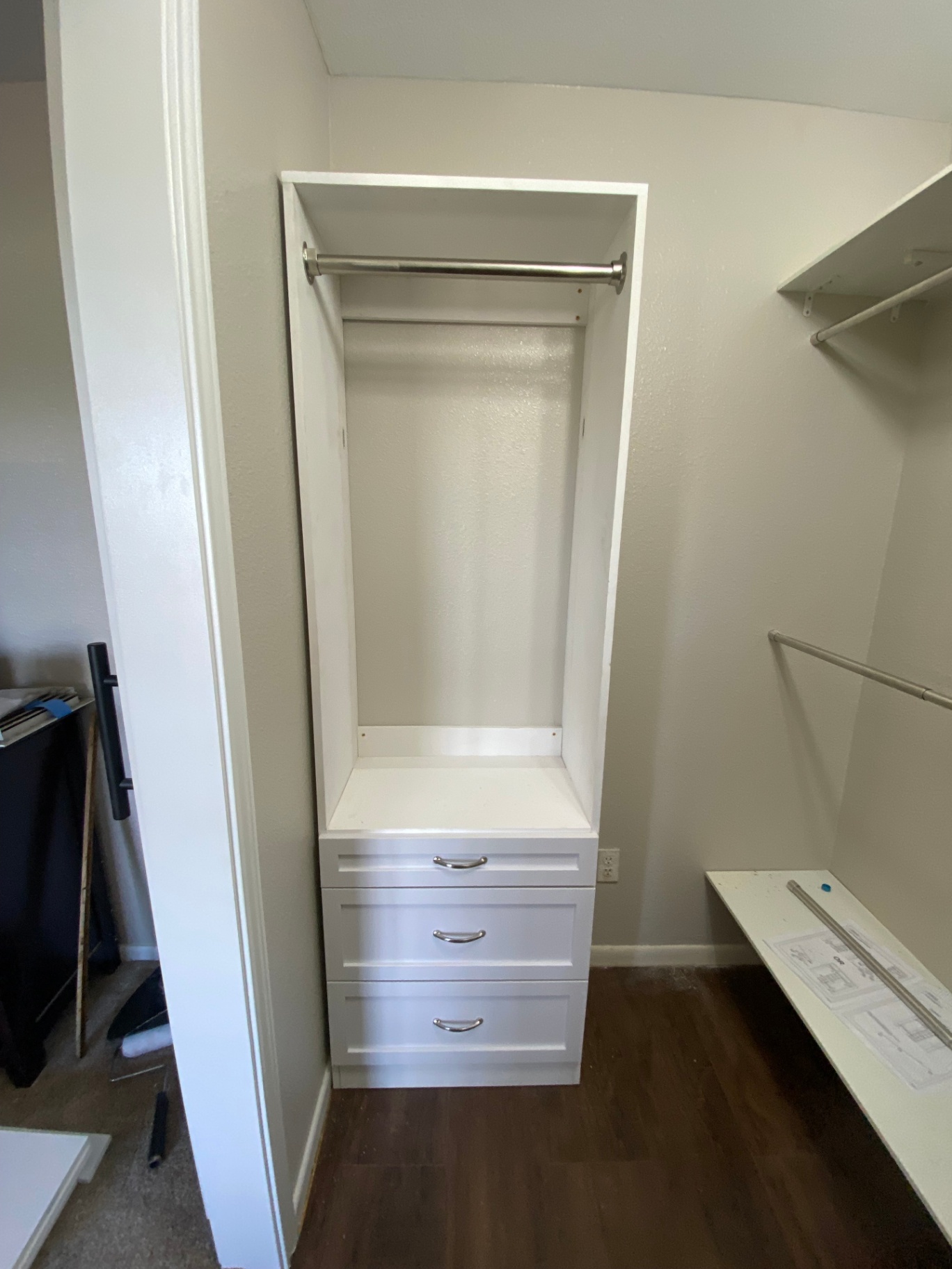 Custom closet built-in with drawers and hanging rod installed in a bedroom closet