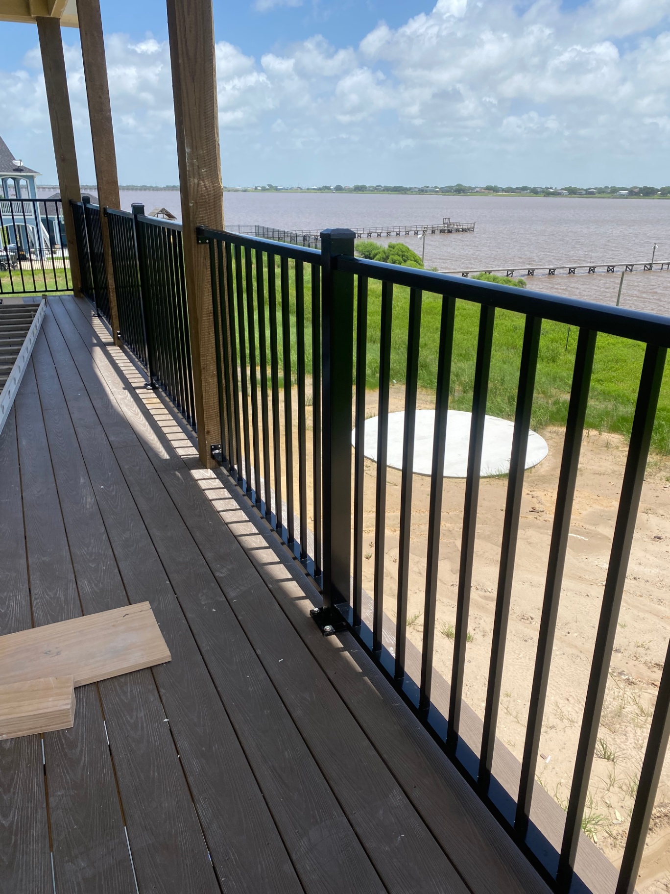 Black metal railing installed on a covered deck overlooking the water
