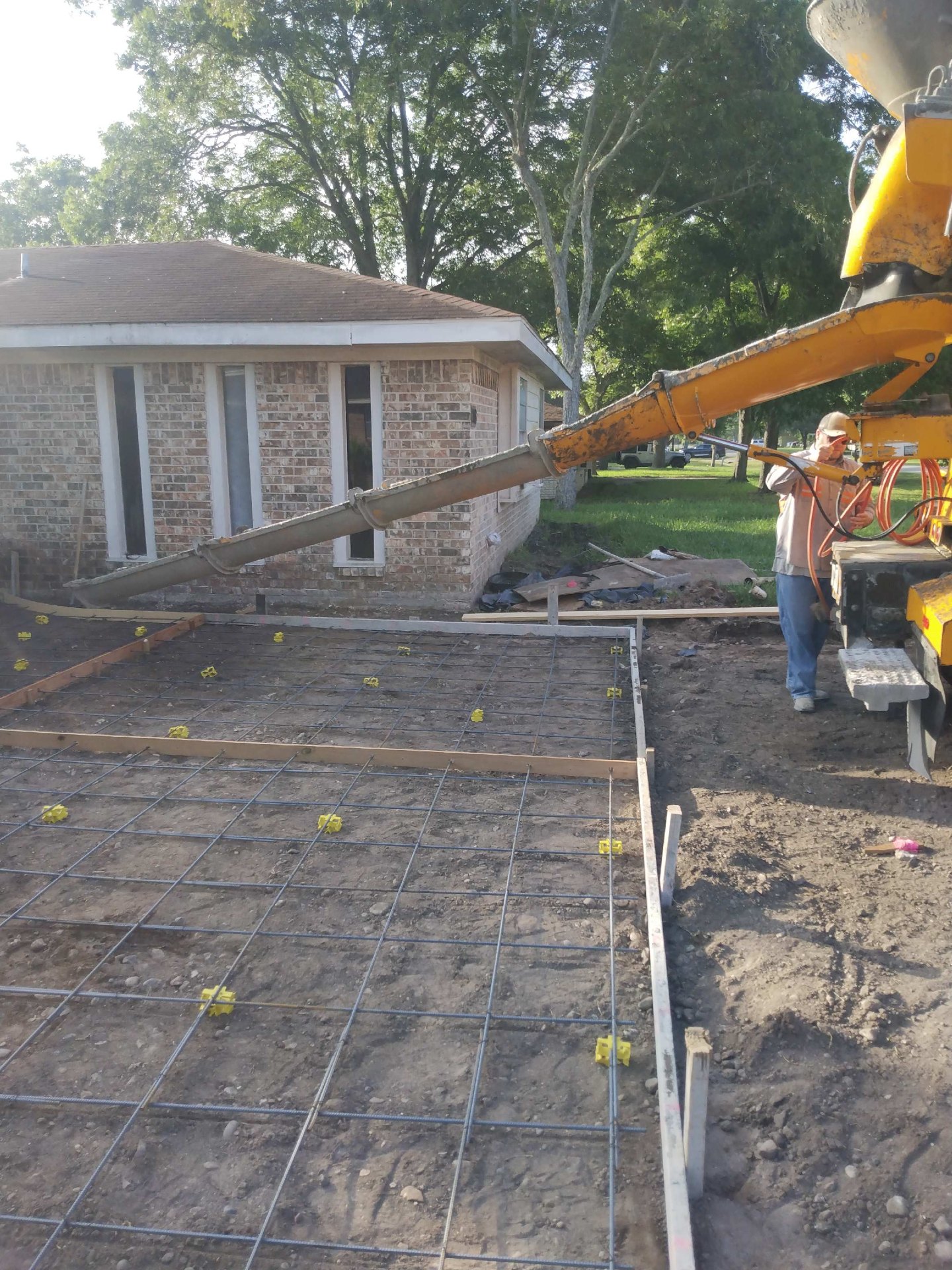 Concrete pump truck pouring a new driveway with rebar and forms