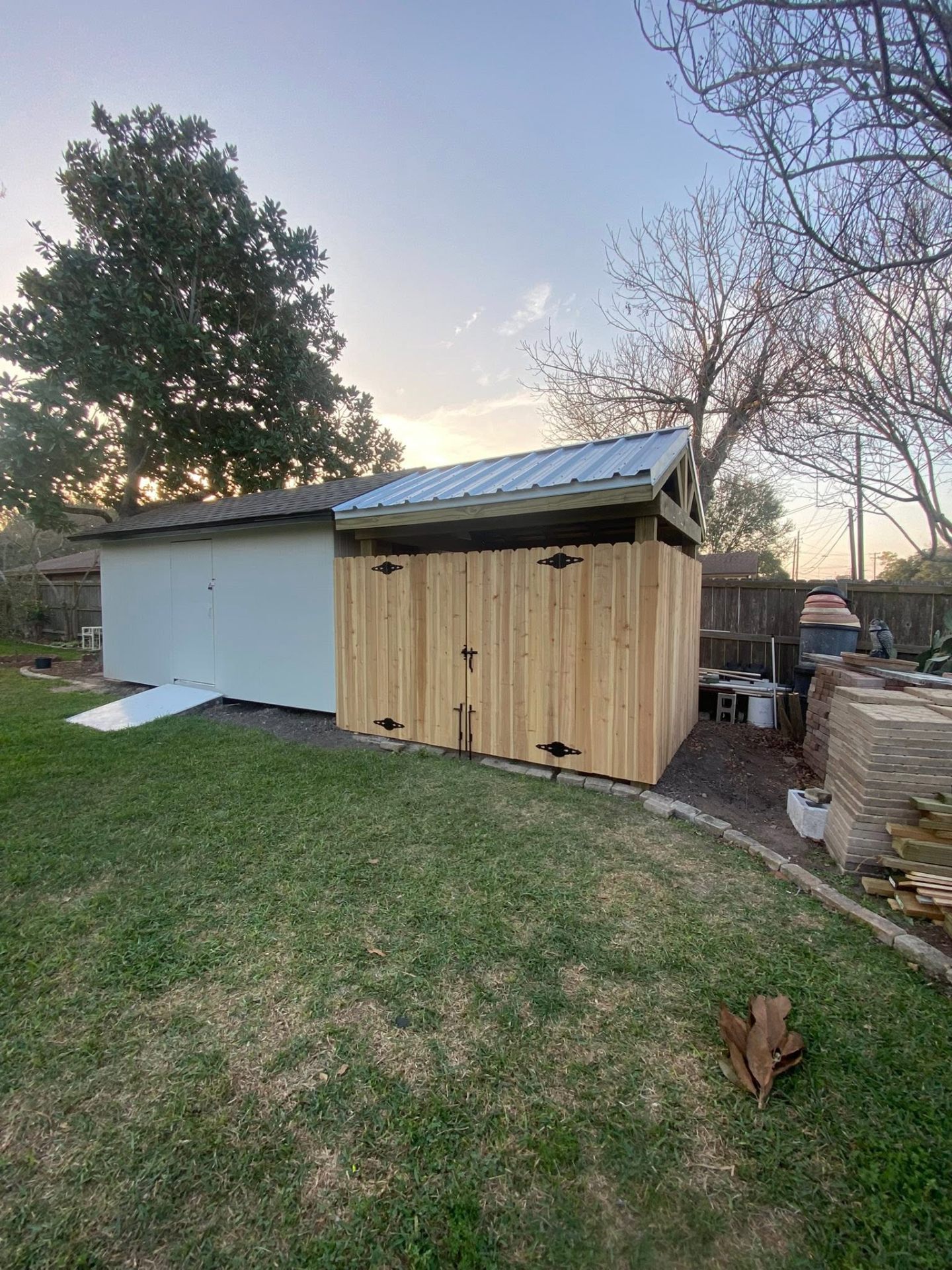Custom cedar storage shed with metal roof in a Victoria TX backyard